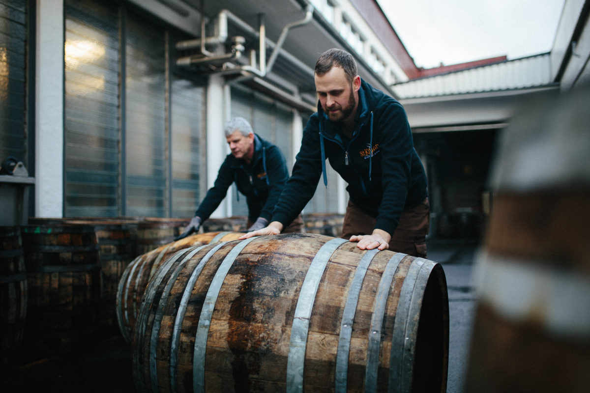 Mario Rudolf rolls barrels across the yard